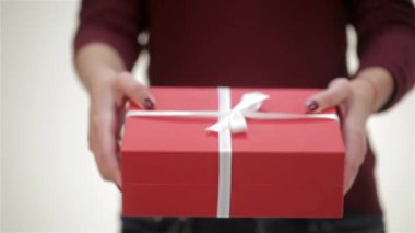 Yakın bir kız hediye verir. Santa şapka genç çekici çift, rahat kazak, gülümseyerek, mutlu bir yeni yıl, Mutlu Noeller, Mutlu Sevgililer Günü, hediyeler sunar, gülerek birbirlerini tebrik