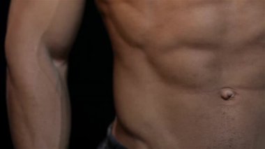 Bir güzel Abs ve göğüs kasları erkek kapatın. Kaslı adam vücut geliştiricisi. Adam siyah bir arka plan üzerinde poz kasları gösterir. Vücut geliştirme, poz, siyah arka plan, kas - kavramı