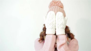 Tatlı kız onun yüzüne eldiven kapsar. Beyaz arka plan üzerinde gülümseyen kız mutlu. Çekici kadın, kız, rahat bir eşarp ile kadın stüdyoda poz. Noel hediyeleri. Coziness Noel kavramı