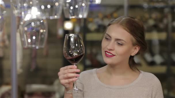 女人喝的酒 年轻漂亮的女人喝葡萄酒 保持眼睛闭上 消费和人们的观念 快乐年轻女性或男性选择和购买葡萄酒或啤酒市场 — 图库视频影像