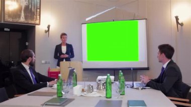 Bir kadın bir gruba iş sunumu yapıyor. İş Konferansı ve Sunumu Sözcüsü. Konferans salonunda dinleyiciler. İş ve Girişimcilik. Uzayı yeşil ekrana kopyala. Hromakey