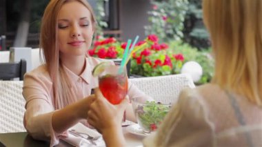 Kokteyl içme ve konuşurken kız. Kadınların rahat kafe terasında sevinir Toplantı