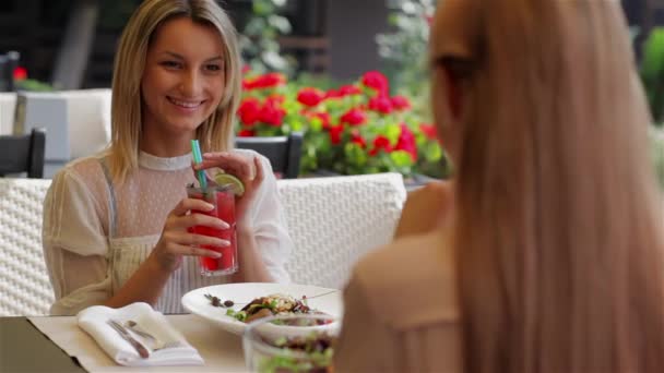 Dos Chicas Hermosas Jóvenes Sentadas Cafetería Urbana Hablando Bebiendo Cóctel — Vídeo de stock