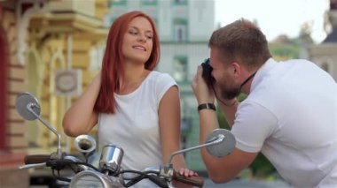 Çekici çift şehirde güneşli bir günde bir scooter üzerinde fotoğrafı