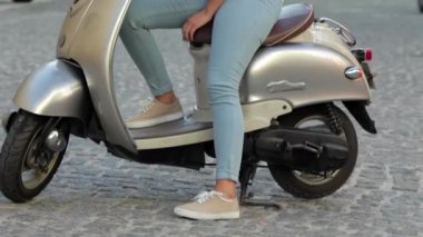 Bir scooter üzerinde oturan genç güzel kadın