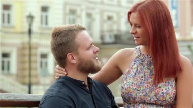 Genç çift parkta bir bankta eğleniyor. Görüntüsü büyüleyici genç insanların birbirlerine aşık olmak. Kız adamın kucağına oturuyor