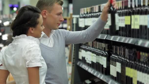 Paar Wählt Wein Supermarkt Aus Weinauswahl Einem Spirituosenladen Fröhliche Einkäufer — Stockvideo