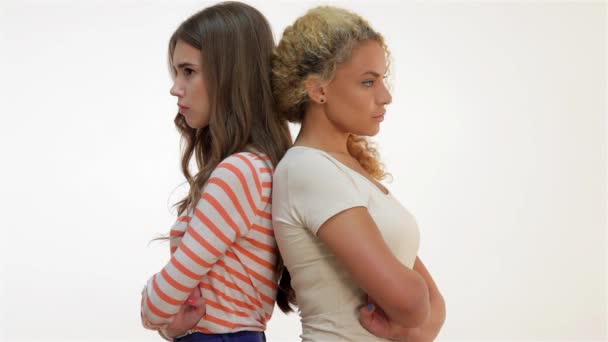 2人のガールフレンドが一緒に立っている ブラウン髪の白髪と赤毛の女の子は喧嘩し お互いに後ろに立った 白い背景にある2人の女の子 — ストック動画