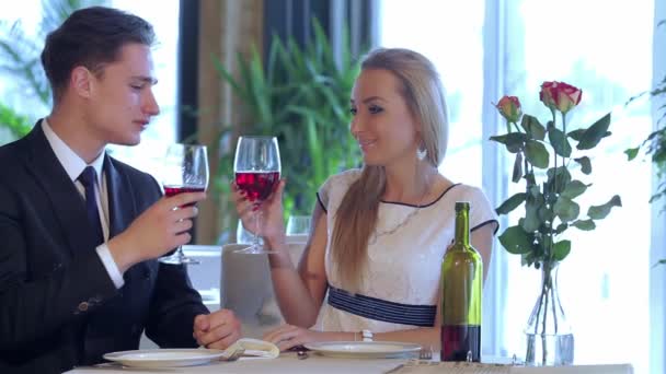 两个人共进午餐 餐厅里的浪漫晚餐年轻夫妇到一家餐馆 举杯喝酒 而男人则牵着一个女人的手 年轻的爱人 — 图库视频影像