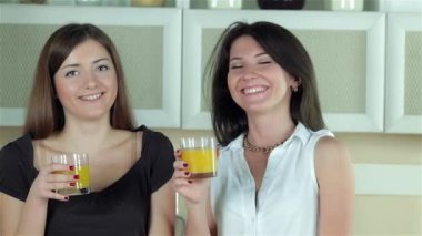 Kameraya gülümseyen suyu gözlük iki kızla. Genç gülümseyen arkadaşlar kesilmiş sebzeler ise mutfakta yemek. Birlikte yemek yiyecek.