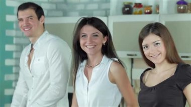 Üç arkadaş kendilerini sağlıklı yemek ve doğrudan kameraya gülümseyen hazırlıyor. Genç gülümseyen arkadaşlar kesilmiş sebzeler ise mutfakta yemek. Birlikte yemek yiyecek.