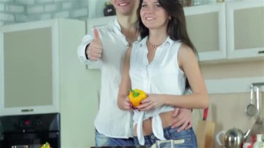 Dans kız biber, holding adam kucaklama kız bel, sonra bir başparmak ortaya çıkarlar. Genç gülümseyen arkadaşlar kesilmiş sebzeler ise mutfakta yemek. Birlikte yemek yiyecek.