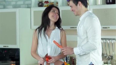 Kaç sebze güveç için kıyılmış. Genç gülümseyen arkadaşlar kesilmiş sebzeler ise mutfakta yemek. Birlikte yemek yiyecek.