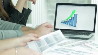 Satış büyüme çizelgeleri. Kendine güvenen işçi işi. Gülümseyen işadamı masada oturan ve bir dizüstü bilgisayara bir iş planı yazarak.