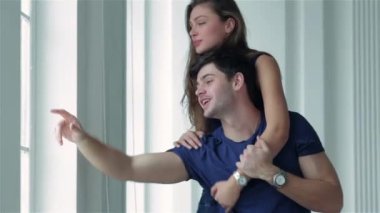 Muhteşem merkezi konumu. Bir kız ve ellerini hareket ve birkaç içinde aşk yeni daire penceresinde ayakta iken gülümseyen bir adam