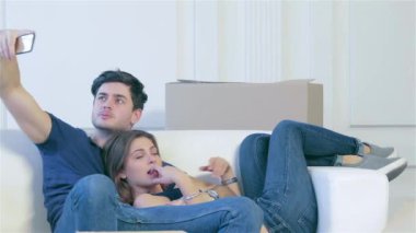 Yeni bir hayata değişen. Bir kız ve bir adam elinde taşıma ve birkaç içinde aşk selfie vasıl belgili tanımlık pencere kutuları arasında yapım sırasında telefon kameraya gülümseyen kutuları