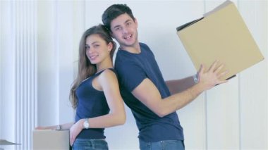 Hareketli, değişen, yeni daire. İki kız ve adam hareketli kutular elinde tutup, erkek ve kadın arasında boş bir daire kutularına kanepe arkasında ayakta iken kameraya bakıyor