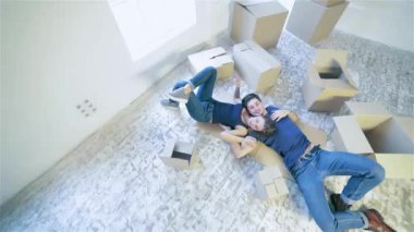Hareketli, onarım, yeni ev. Bir kucaklama erkek ve kadın arasında boş bir daire içinde belgili tanımlık boksör katta yatan süre yerde kaç kız ve adam yalan