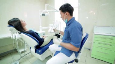 Muayenede, genç başarılı dişçi. Diş hekimi aracın daha yakın hasta dişçi koltuğunda oturmak için seçer ve onu gülümseyerek konuşuyor