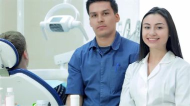 Yeni çalışma günü diş hekimleri. Yanında kız stajyer Şef-dişçi. Onlar are diş gülümseme o zaman başparmak yukarıya