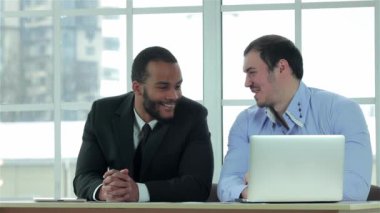 İş iş. İki başarılı işadamı ofis ve çalışma onun laptop müzakere masasına otur. İş adamları formal giyim giyinmiş