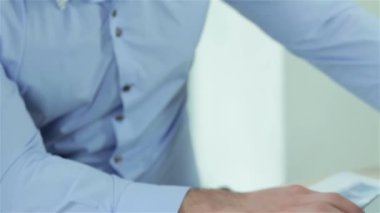 Takım çalışması. İşadamları dizüstü bilgisayarda çalışırken ofiste pazarlık masasında oturan azimli iş adamı. Resmi giyinmiş iş adamları