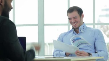 İş sözleşmesi kontrol. Ofiste müzakere masasına oturan ve onun laptop çalışma iki başarılı iş adamı. İş adamları formal giyim giyinmiş