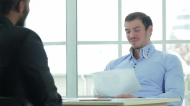 İşadamları müzakereleri. İki başarılı bir iş adamı pazarlığı oturan ofiste masa ve geçirmek ile her diğer. İş adamları formal giyim giyinmiş