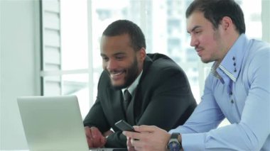 Meşgul iş adamı. İş adamları bir dizüstü bilgisayar çalışma sırasında ofiste müzakere masasına oturan iki kendine güvenen bir iş adamı. İş adamları formal giyim giyinmiş
