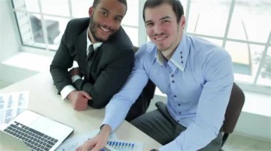 Başarılı iş takım. Gülümseyen ve ofis ve formal giyim ararken onun masasında parmağını gösterilmesini iki başarılı iş adamı.