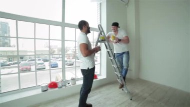 Çay saati. İki işçi break ve yapmak yeni bir dairede tamirat sonra snack. Bir adam başka bir adamla merdivenin boya alır