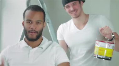 Taşıma ve onarır dairede. Genç bir işçi erkek arkadaşı boş bir dairede bir merdiven üzerinde arka planda ayakta iken bir başparmak gösterilmesini