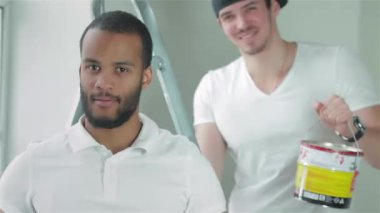 Taşıma ve onarır dairede. Genç bir işçi erkek arkadaşı boş bir dairede bir merdiven üzerinde arka planda ayakta iken bir başparmak gösterilmesini