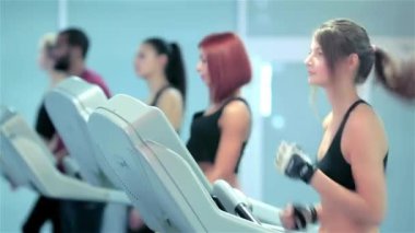 Isınma çalıştırın. Spor ve ince kız bir koşu bandı üzerinde çalışan. Spor üniforması giymiş ve spor salonunda çalışan atlet