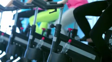 Sağlık için bisiklet. Dört kız sporcu gidin ve jimnastik salonu sabit bir bisiklet üzerinde oldu
