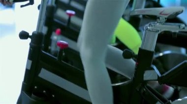 Bisiklet üstünde antrenman. Atletik kız simülatörde pedal çeviriyor. Ta ki dört kız arkadaşı spor salonunda bisikletle pedal çevirene kadar.