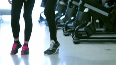 Mükemmel fitness egzersiz. Onların arkadaşları sporda söz konusu iken poz ve sabit bir bisiklet üzerinde pedal iki güçlü ince kız