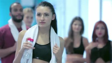 Bir kız sporcular portresi. Genç sporcu arkadaşları arka plan üzerinde kamera poz