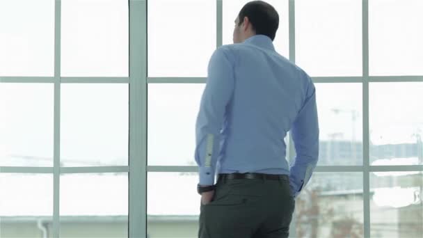 ビジネスを行うには時間 事務所の窓の近くに立っている間彼の時計見て正式な摩耗で陽気で成功した実業家 — ストック動画