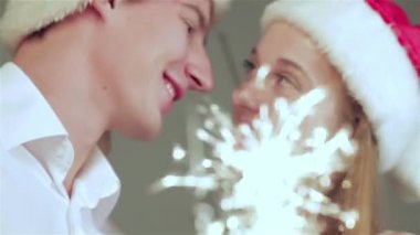 Noel mobilyalı bir odada hediyeler tutan kazak ve eşarp giymiş sevgi dolu bir çift. Aşık adam genç çift ve evde kazak ve eşarp giyen güzel kız.