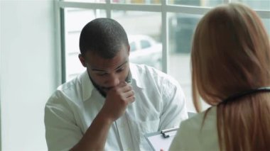 Özenli doktor hastayı dinler ve en iyi kliniklerde teşhis eder. Gülümseyen doktor hastayı dinler ve hastanede ilaç için reçete yazar koyar. Kibar doktor