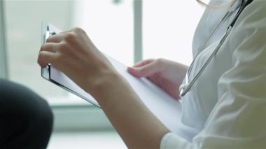 Özenli doktor hastayı dinler ve en iyi kliniklerde teşhis eder. Gülümseyen doktor hastayı dinler ve hastanede ilaç için reçete yazar koyar. Kibar doktor