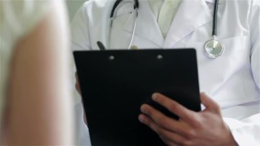 Özenli doktor hastayı dinler ve en iyi kliniklerde teşhis eder. Gülümseyen doktor hastayı dinler ve hastanede ilaç için reçete yazar koyar. Kibar doktor