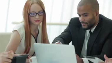 Bir toplantıda gülümseyen işadamı. İş arkadaşlarıyla iş toplantısı. Dört gülümseyen başarılı işadamları ofiste masada oturuyor.