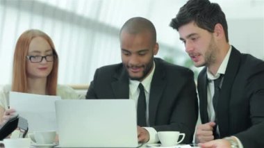 Bir toplantıda gülümseyen işadamı. İş arkadaşlarıyla iş toplantısı. Dört gülümseyen başarılı işadamları ofiste masada oturuyor.