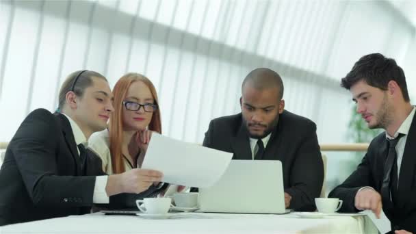 会議で笑顔のビジネスマン 同僚とのビジネスミーティング オフィスのテーブルに座っている4人の笑顔の成功したビジネスマン — ストック動画