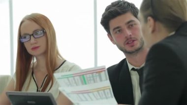 Bir toplantıda gülümseyen işadamı. İş arkadaşlarıyla iş toplantısı. Dört gülümseyen başarılı işadamları ofiste masada oturuyor.