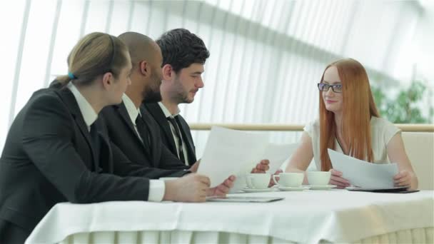会議で笑顔のビジネスマン 同僚とのビジネスミーティング オフィスのテーブルに座っている4人の笑顔の成功したビジネスマン — ストック動画