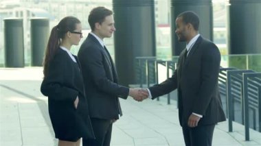 Konuksever yeni ortaklar. İş adamları resmi elbise sokakta buldum gülen grubu. İş ilişkileri.