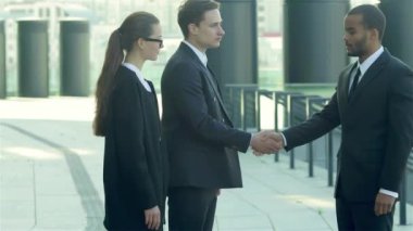 Konuksever yeni ortaklar. İş adamları resmi elbise sokakta buldum gülen grubu. İş ilişkileri.